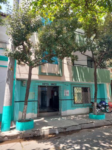 Hotel Unico City في سانتا مارتا: مبنى ازرق امامه اشجار