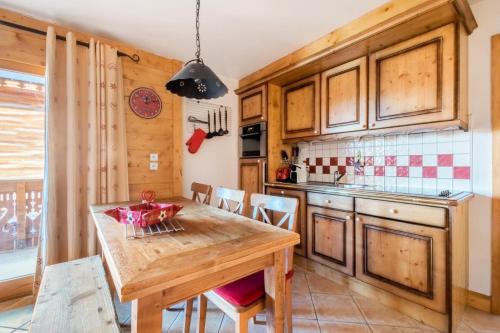 une cuisine avec une table et des chaises en bois dans l'établissement Appartement 3 pièces 6 pers proche pistes - maeva Home - 3 Pièces 6 Personnes Sélection MAE-4880, à Arâches-la-Frasse