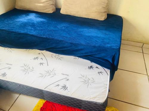 Una cama con una manta azul encima. en Tranquilidade na Chapad dos Veadeiros, en Cavalcante