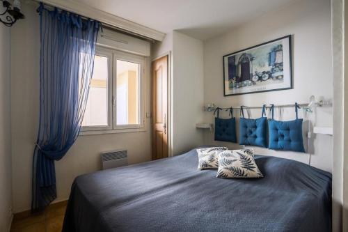 - une chambre dotée d'un lit bleu avec deux oreillers dans l'établissement Appartement 3 pièces 4 pers proche commerces 75057, à Sainte-Maxime