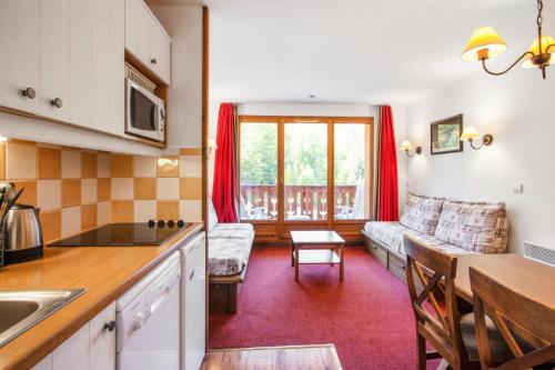 une cuisine et un salon avec un canapé et une table dans l'établissement Résidence L'Albane - maeva Home - Appartement 2 pièces 5 personnes Sélection MAE-7977, à Vars