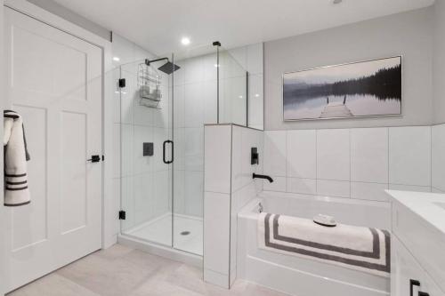 baño blanco con ducha y lavamanos en Lakeside Escape at the Oasis, en Harrison Hot Springs