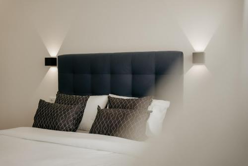 un letto con testiera blu e cuscini sopra di A 0.4 - Alexa Smart House a Braga