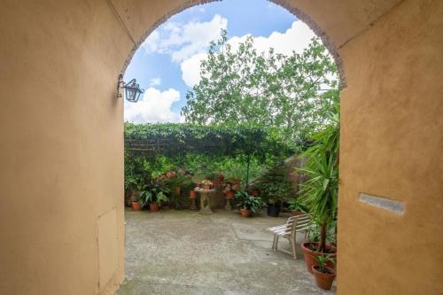 un arco que conduce a un jardín con macetas en Ferienwohnung Rosa in der Residenza dei Piaceri Perduti, en Lastra a Signa