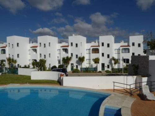 un complexe avec une piscine en face d'un bâtiment dans l'établissement Apartamento encantador a 100m da praia, à Carvoeiro