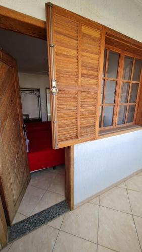 a wooden cabinet in a room with a red couch at Hotel e Pousada Ed1000son in São João del Rei