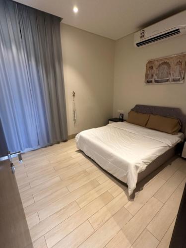 a bedroom with a bed and a wooden floor at Abu sjood in Salalah