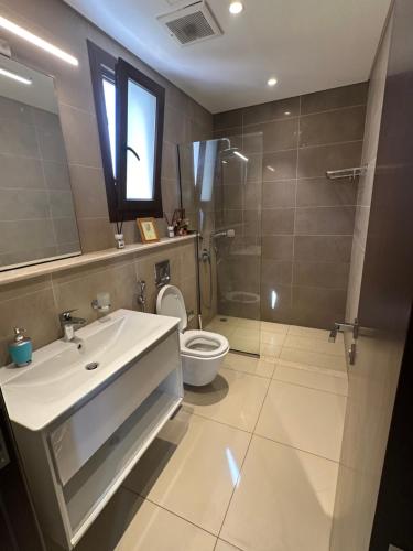 a bathroom with a sink and a shower and a toilet at Abu sjood in Salalah