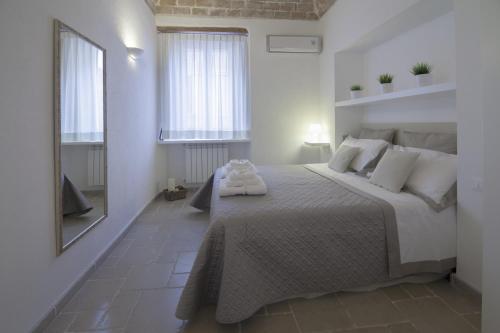 een witte slaapkamer met een groot bed met witte kussens bij Numero 85 in Termoli