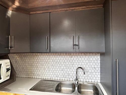 a kitchen with stainless steel cabinets and a sink at Katlego in Bloemfontein