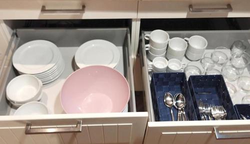 a cabinet filled with white dishes and spoons at Casa Melé 3, Parking privado opcional in Lleida