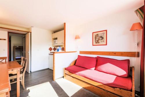 un salon avec un canapé rouge et une table dans l'établissement Résidence Les Mélèzes - maeva Home - Appartement 2 Pièces 6 Personnes Selection MAE-1345, à Huez
