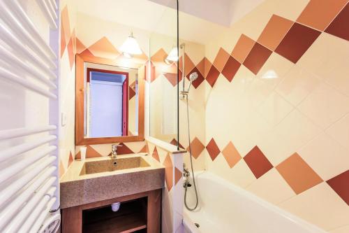 une salle de bain avec un lavabo, un miroir et une baignoire dans l'établissement Résidence Les Mélèzes - maeva Home - Appartement 2 Pièces 6 Personnes Selection MAE-1345, à Huez