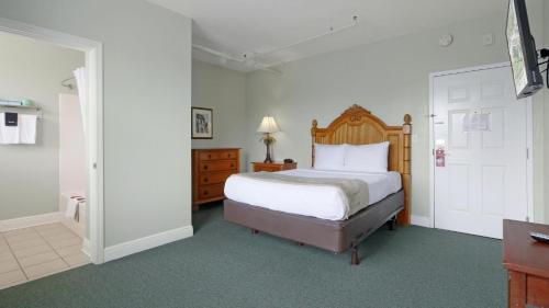 a bedroom with a bed with a wooden headboard at Crystal Bay Historic Hotel in St Petersburg