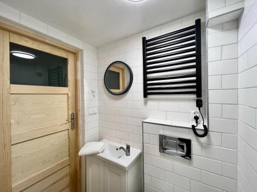 a white bathroom with a sink and a mirror at Na Skraju Lasu Domek na Drzewie & Glamping in Kazimierz Dolny