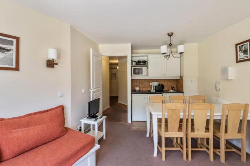 un salon avec un canapé et une table et une cuisine dans l'établissement Résidence Sépia - maeva Home - Appartement 3 pièces 7 personnes Sélection MAE-1964, à Morzine