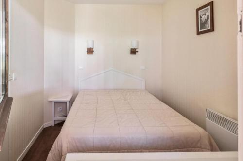 une chambre avec un lit dans une pièce blanche dans l'établissement Résidence Sépia - maeva Home - Appartement 2 pièces 5 personnes Sélection MAE-1966, à Morzine