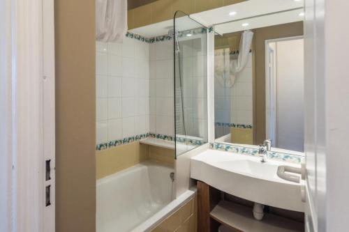 une salle de bain avec un lavabo, une baignoire et un miroir dans l'établissement Résidence Sépia - maeva Home - Appartement 2 pièces 5 personnes Sélection MAE-1966, à Morzine