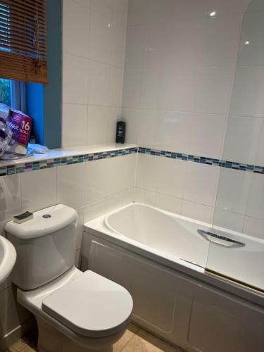 a bathroom with a toilet and a bath tub at Luxury 2 Bed Apartment With Parking in Derby