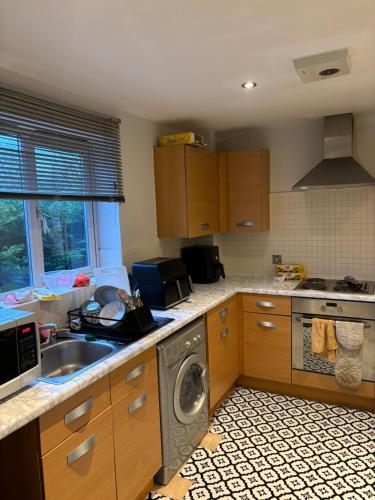 a kitchen with a sink and a washing machine at Luxury 2 Bed Apartment With Parking in Derby