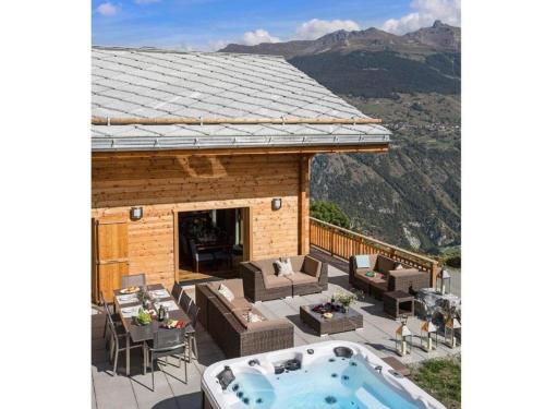 una casa con vasca idromassaggio su una terrazza con montagna di Chalet des Etoiles Les Masses a Hérémence