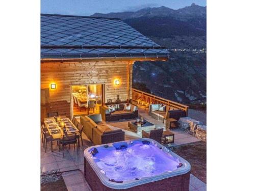 a hot tub on the patio of a house at Chalet des Etoiles Les Masses in Hérémence
