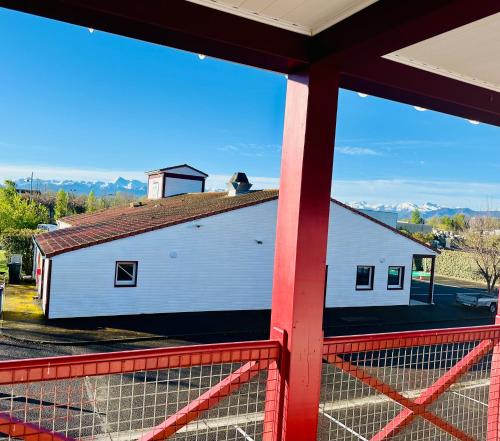 a white barn with a dog on the roof at Ever Route 64 Brit Hotel Tarbes Ibos in Tarbes