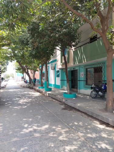 Hotel Unico City في سانتا مارتا: مبنى أزرق مع أشجار على جانب الشارع