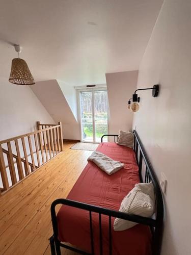 - une chambre avec un lit rouge et un escalier dans l'établissement Maison vue sur la nature proche golf & Carnac, à Ploemel