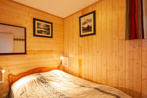une chambre avec un lit dans un mur en bois dans l'établissement Résidence Les Horizons d'Huez - maeva Home - Appartement 2 Pièces 5 Personnes - Sélection MAE-2698, à Huez