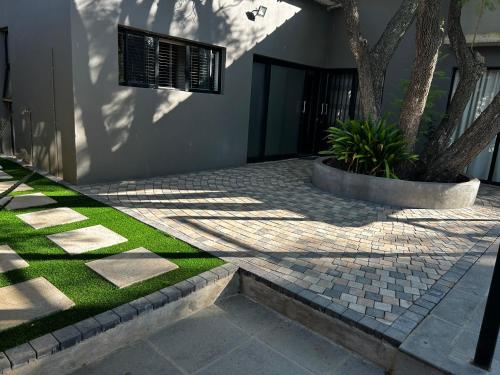 a shadow of a tree on a building with grass at Katlego in Bloemfontein