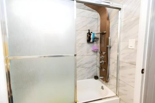 a shower with a glass door in a bathroom at Skyline 3 BR 20mins to T-Square #3 in West New York