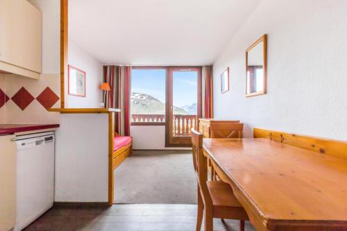 Il comprend une cuisine et une salle à manger avec une table en bois. dans l'établissement Résidence Les Mélèzes - maeva Home - 2 pièces 6 pers Confort MAE-3394, à Huez