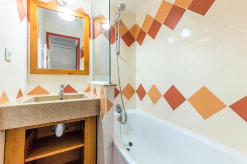 une salle de bain avec un lavabo, une baignoire et un miroir dans l'établissement Résidence Les Mélèzes - maeva Home - 2 pièces 6 pers Confort MAE-3394, à Huez