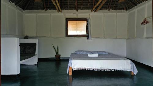 a bedroom with a bed in a room with a window at Piecefull bayview Cottage with Kitchen near Tofo in Inhambane
