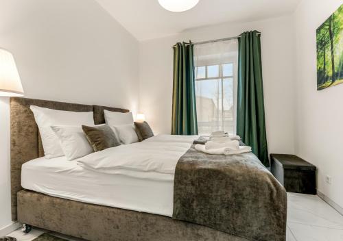 1 dormitorio con 1 cama grande y cortinas verdes en LoC-Luxus Apartment nahe Oldenburg, en Wardenburg