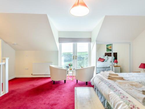 a bedroom with a large bed and two chairs at 1 Bed in Swimbridge LANEE in Swimbridge