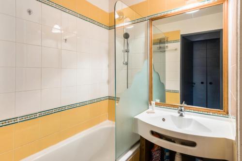 une salle de bain avec un lavabo, une baignoire et un miroir dans l'établissement Résidence Le Douchka - maeva Home - Appartement 2 pièces 5 personnes Confort MAE-6972, à Morzine
