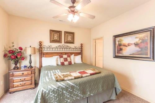 a bedroom with a bed and a ceiling fan at Branson Condo with a Walkout and Elevator Access at Thousand Hills and next to 76 in Branson