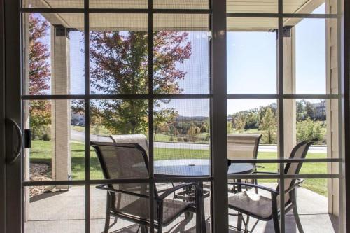 a table and chairs on a screened in porch with a view at Branson Condo with a Walkout and Elevator Access at Thousand Hills and next to 76 in Branson