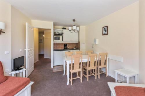 Il comprend un salon et une cuisine avec une table et des chaises. dans l'établissement Résidence Sépia - maeva Home - 3 pièces 7 pers Sélection MAE-5877, à Morzine