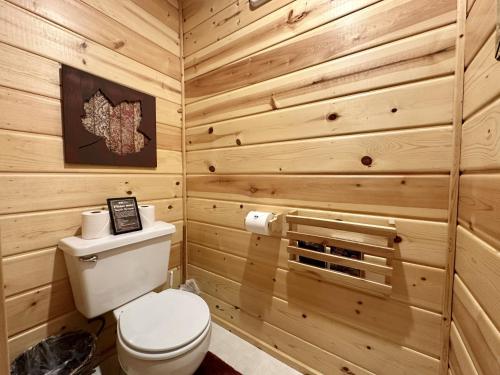a bathroom with a toilet and wooden walls at Chipmunk Lodge by NW Comfy Cabins in Leavenworth