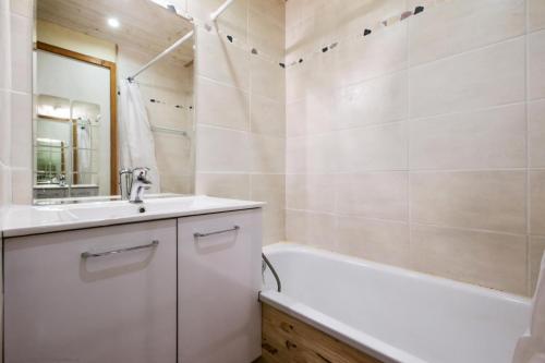 une salle de bain avec une baignoire et un lavabo et une baignoire dans l'établissement Résidence L'Ours Blanc - maeva Home - Appartement 2 Pièces 4 personnes - Sélection MAE-7573, à Huez