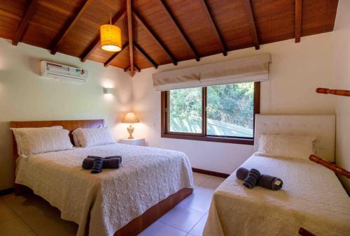 1 Schlafzimmer mit 2 Betten und einem Fenster in der Unterkunft Paraíso Buziano 1 in Búzios