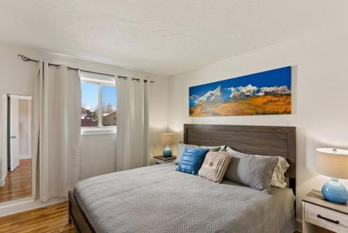 a bedroom with a large bed with blue pillows at Mountainside Condo King Bed, Two Hot Tubs, Fireplace, Pool , on the Free Bus Route in Steamboat Springs