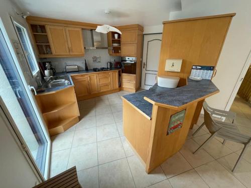 une cuisine avec des armoires en bois et un comptoir dans l'établissement Maison familiale Cosy plage à pied, à Arzon