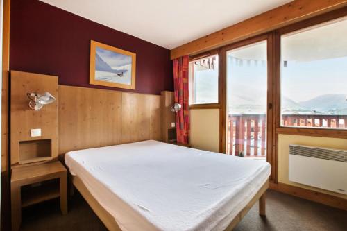une chambre avec un lit et une grande fenêtre dans l'établissement Résidence L'Ours Blanc - maeva Home - Appartement 3 pièces 7 personnes - Sélection MAE-8949, à Huez