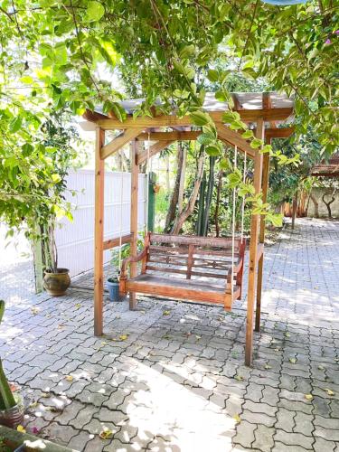 um banco de madeira sentado sob um gazebo em Casa na praia de Ingleses Floripa em Florianópolis