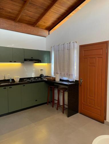 uma cozinha com armários verdes e uma porta de madeira em Casa na praia de Ingleses Floripa em Florianópolis