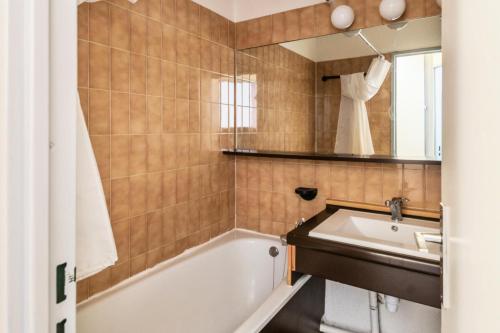 une salle de bain avec une baignoire et un lavabo dans l'établissement Résidence Les Alpages - maeva Home - 2 pièces 5 personnes Confort MAE-0480, à Morzine